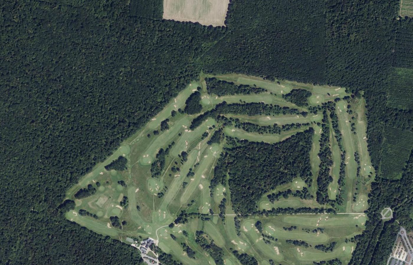 Vue aérienne d'un golf de 18 trous dessiné dans une forêt, fairways et bunkers